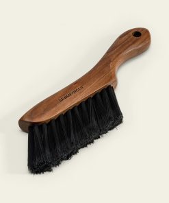 La Marzocco walnut barista brush on a coffee counter