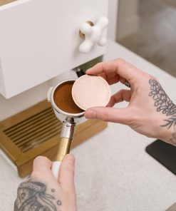 Placing the Cafe Concetto Puck Screen on top of the tamped coffee