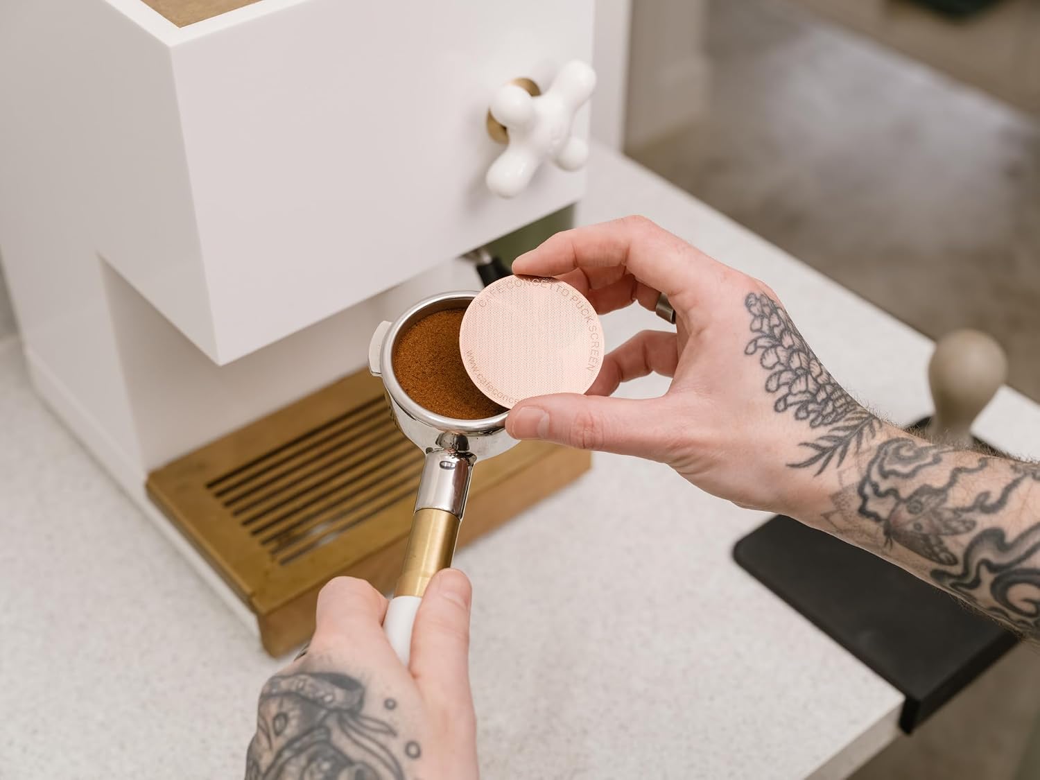 Placing the Cafe Concetto Puck Screen on top of the tamped coffee