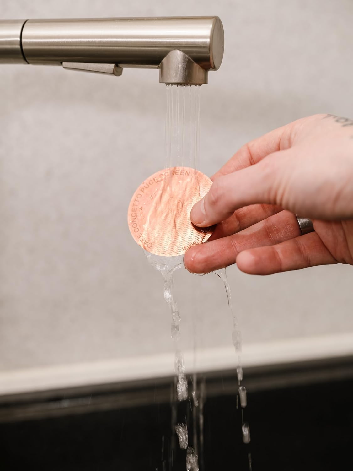 Rinsing the Cafe Concetto Puck Screen under the tap