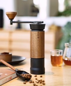 Black and walnut Millab M01 hand grinder on a wooden table