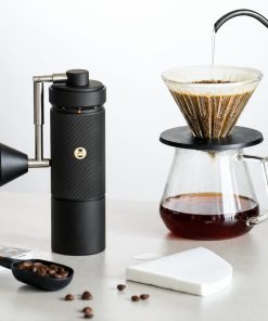 Black Timemore S5 Pro grinder beside a pour-over dripper and glass server