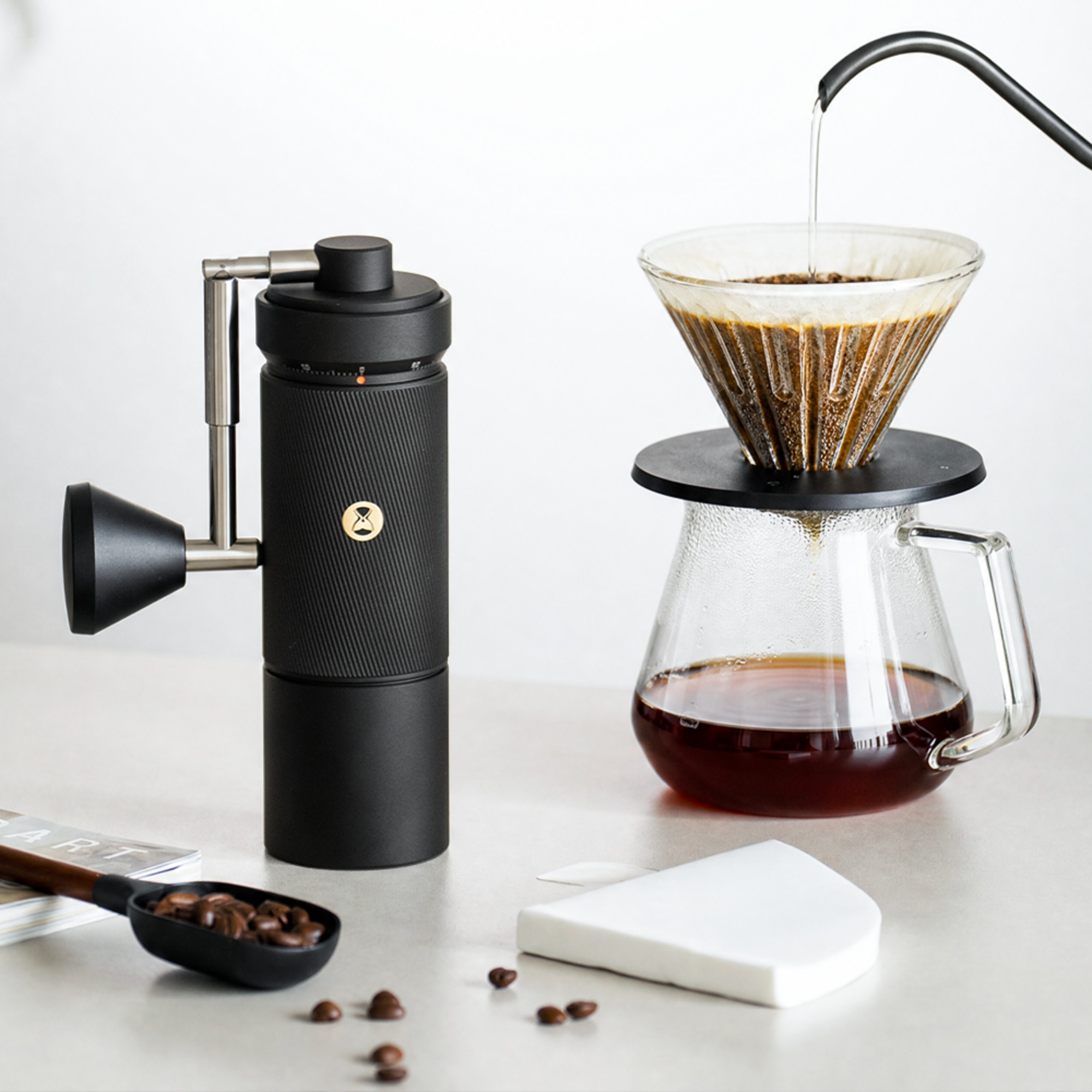 Black Timemore S5 Pro grinder beside a pour-over dripper and glass server