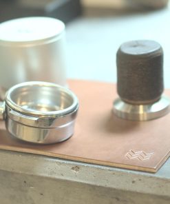 Natural Weber Workshops leather tamping mat on a counter with portafilter, tamper and Blind Shaker