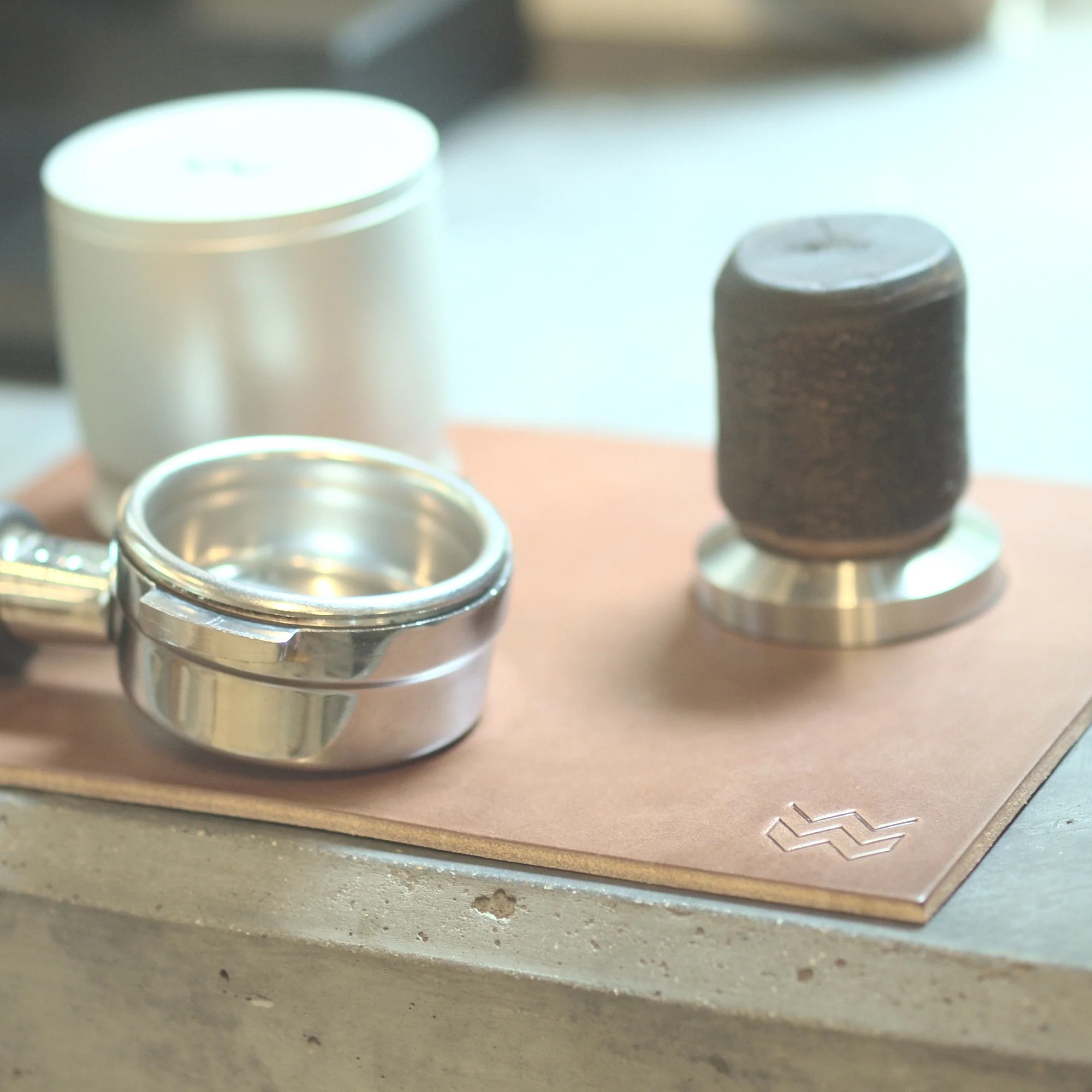 Natural Weber Workshops leather tamping mat on a counter with portafilter, tamper and Blind Shaker