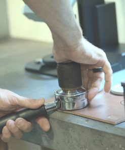 Barista tamping a portafilter on the Natural Weber Workshops leather tamping mat