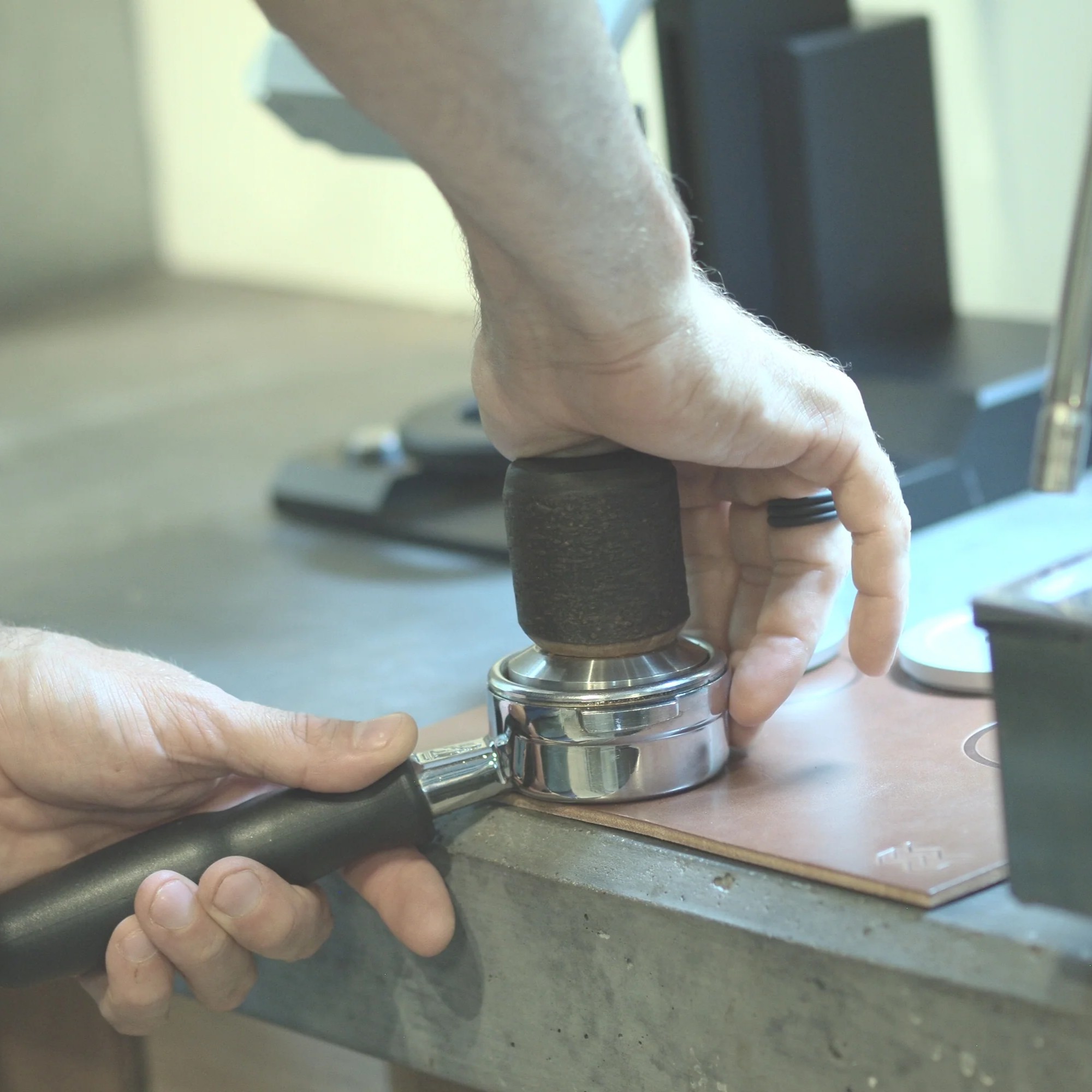 Barista tamping a portafilter on the Natural Weber Workshops leather tamping mat